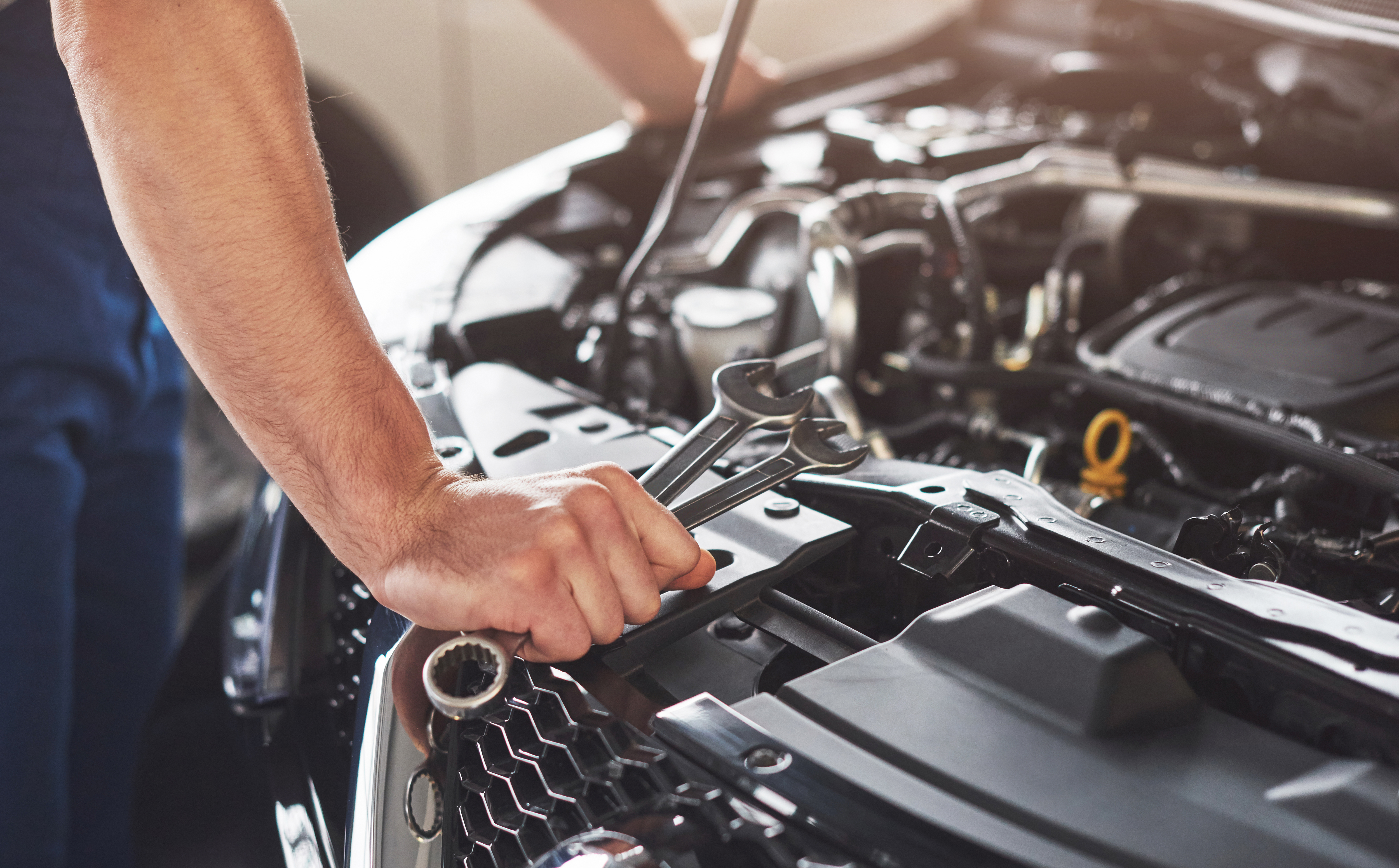Picture showing muscular car service worker repairing vehicle Picture showing muscular car service worker repairing vehicle.
